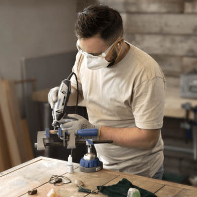 Homem a usar ferramenta elétrica numa oficina de madeira