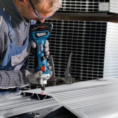 Homem a cortar painel metálico com ferramenta Bosch em fábrica