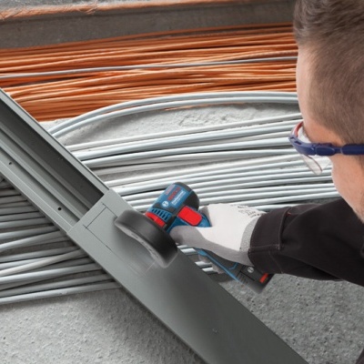 Homem a usar ferramenta elétrica perto de cabos elétricos em bobinas