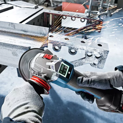 Pessoa com luvas a usar rebarbadora elétrica para cortar metal com faíscas