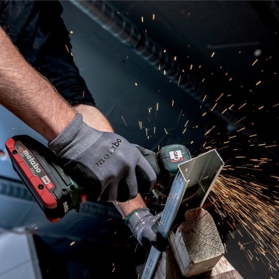 Pessoa a usar ferramenta elétrica a cortar metal com faíscas