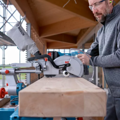 Serra de esquadria Bosch a cortar madeira com operador em obra