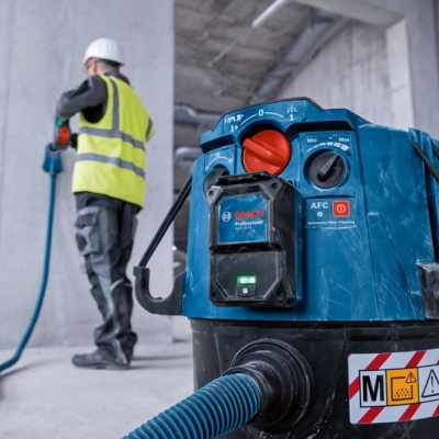 aspirador industrial azul com etiquetas de segurança em obra