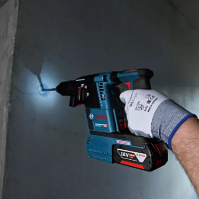 Martelo perfurador a bateria Bosch Professional em uso numa parede cinza