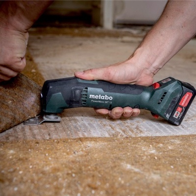 Ferramenta elétrica Metabo a ser usada para cortar material castanho.