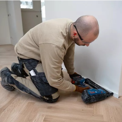 Homem a aspirar chão em interior com aspirador