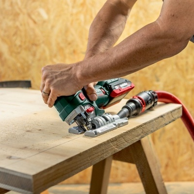 Pessoa a usar lixadora elétrica numa superfície de madeira