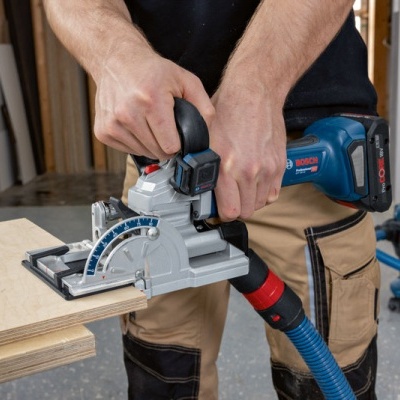 Pessoa a usar serra circular Bosch para cortar madeira numa oficina