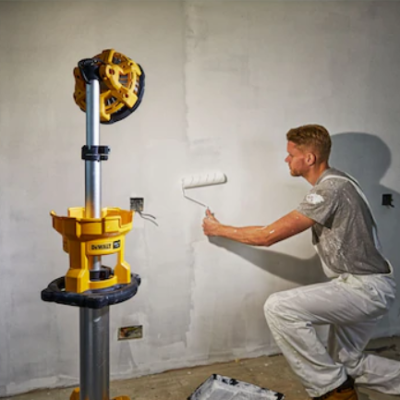 Homem usando máquina DEWALT para pintar parede branca