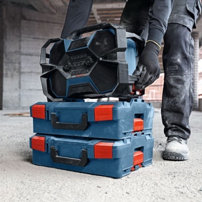 Caixas azuis e rádio portátil com detalhes pretos e vermelhos em ambiente industrial