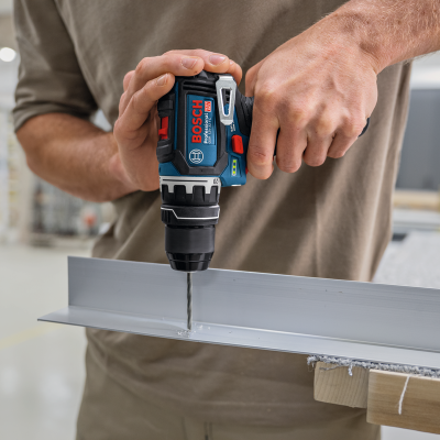 Máquina de perfuração Bosch a funcionar numa peça metálica na oficina