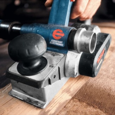 Lixadora elétrica azul e cinza com pega preta em uso sobre madeira clara