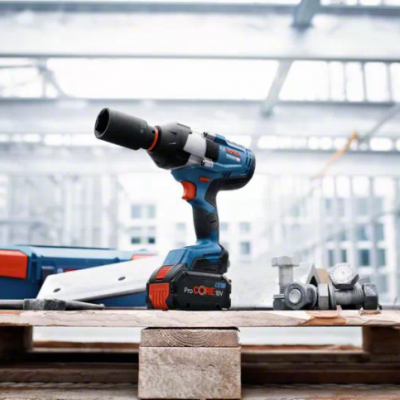 Parafusadora ou broca eléctrica azul e preta com detalhes vermelhos sobre superfície de madeira