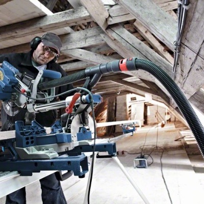 Serra de esquadria azul em sótão com vigas de madeira