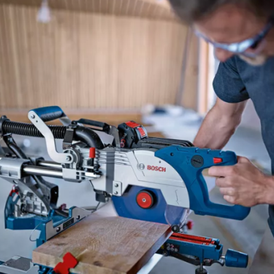 Serra de esquadria Bosch azul e branca operada por pessoa com óculos de proteção
