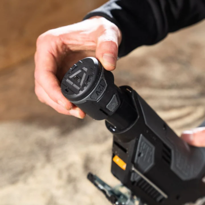 Pistola de pintura preta com bateria 12V segurada por uma mão