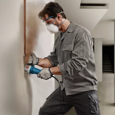 Homem com equipamento de proteção a trabalhar numa parede interior