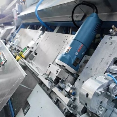 Linha de produção industrial com máquina azul e homem ao fundo