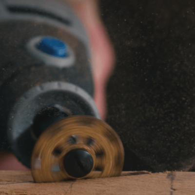 Ferramenta rotativa elétrica com disco abrasivo dourado a cortar madeira