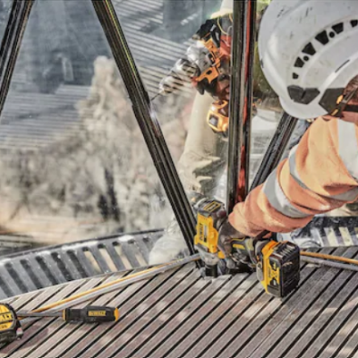 Trabalhador com capacete e parafusadeira elétrica em superfície metálica