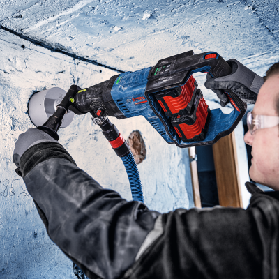 Pessoa a usar ferramenta elétrica Bosch para trabalhar numa parede branca.