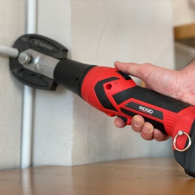 Ferramenta elétrica portátil RIDGID vermelha e preta segurada por uma mão