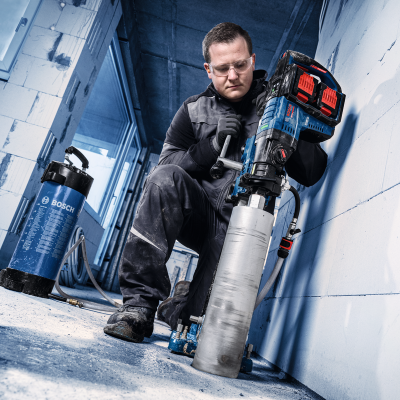 Homem usando máquina perfuradora Bosch azul e preta em ambiente de construção