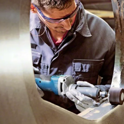 Homem a usar ferramenta elétrica para polir metal