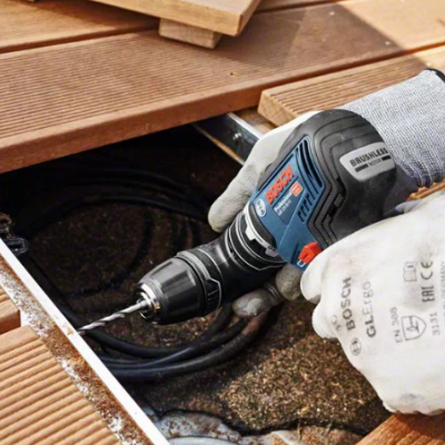 Furadeira Bosch a trabalhar numa estrutura de madeira clara com textura ranhurada