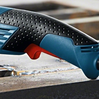 Ferramenta elétrica azul e preta com botão vermelho em superfície metálica