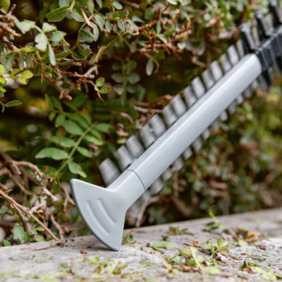 Cabo de aspirador cinzento e preto junto a arbusto verde e superfície de pedra