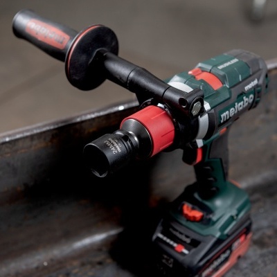 Ferramenta elétrica verde preta e vermelha da marca Metabo numa superfície metálica