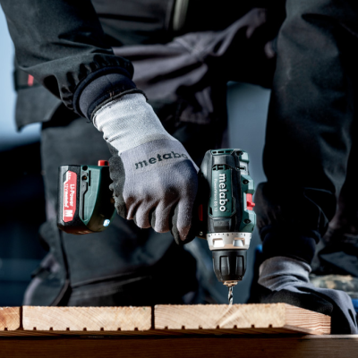 Parafusadeira elétrica Metabo a trabalhar numa tábua de madeira