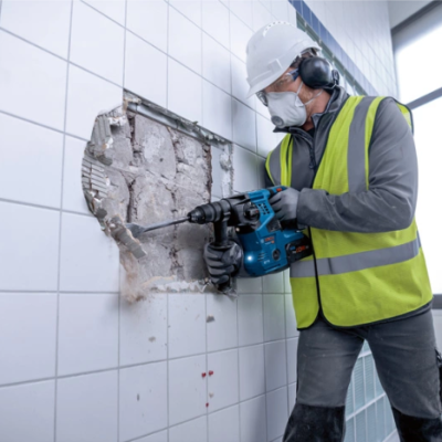 Homem a demolir parede de azulejos com martelo pneumático