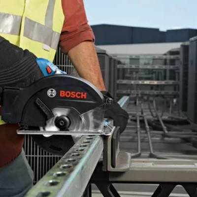 Serra circular a bateria BOSCH a ser usada para cortar metal num ambiente industrial