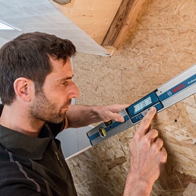 Nível digital BOSCH PROFESSIONAL GIM 120 C a ser usado numa parede de construção