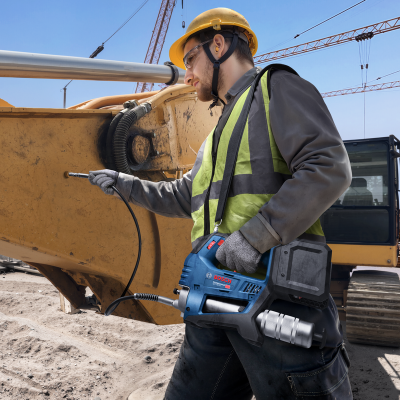 Homem com equipamento de proteção a usar máquina Bosch em estaleiro de construção