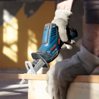 Serra de recortes Bosch azul e preto usada por pessoa com luvas em ambiente de carpintaria
