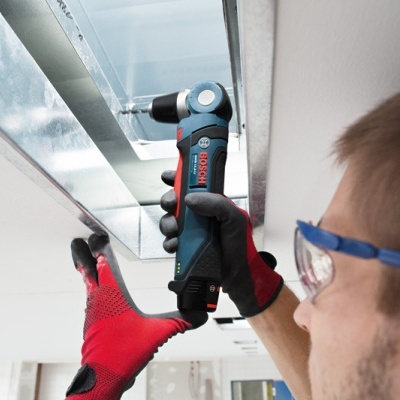 Pessoa usando ferramenta elétrica Bosch para montar estrutura metálica no teto