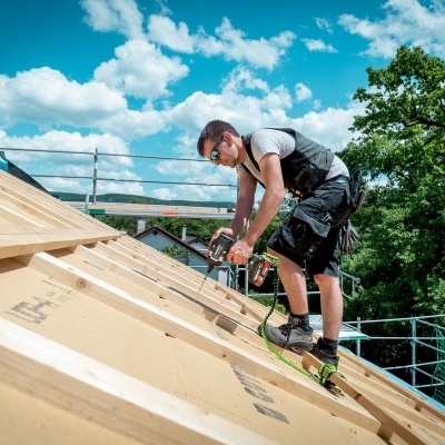 Homem a trabalhar num telhado em construção com equipamento de proteção