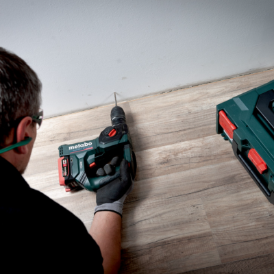 Homem a usar furadeira Metabo para fazer furo numa parede