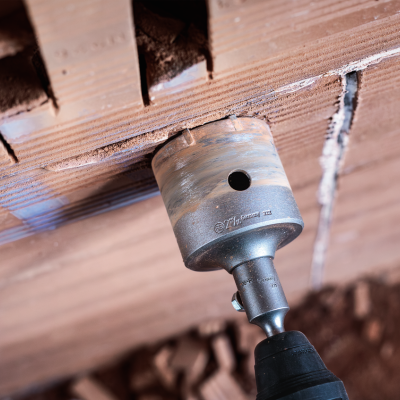 Ferramenta de perfuração em metal na furadeira a perfurar tijolos vermelhos