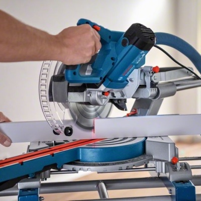 Serra de esquadria azul e preta com suporte metálico e régua, numa bancada de trabalho