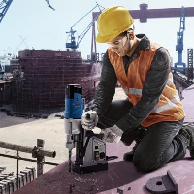 Trabalhador de construção a usar furadora elétrica em superfície metálica