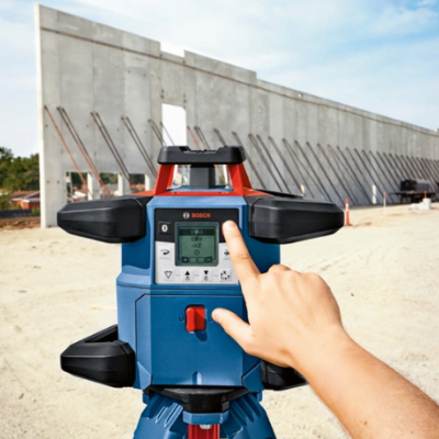 Equipamento BOSCH azul sobre tripé num canteiro de obras