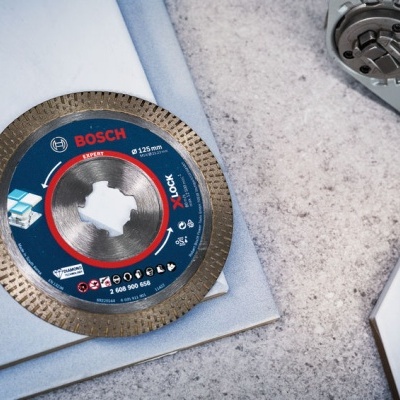 Disco de corte Bosch azul e preto com detalhes vermelhos numa superfície cinza