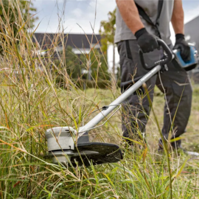 Depressor de relva elétrico a cortar relva alta num jardim