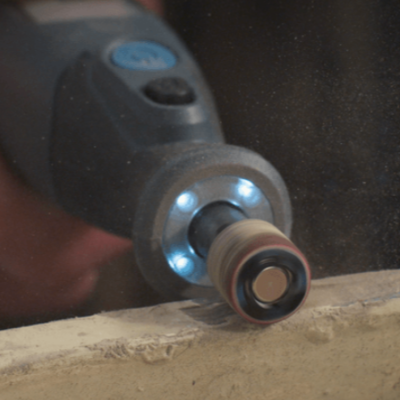 Ferramenta elétrica preta com luzes LED a lixar madeira clara