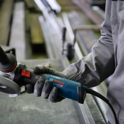 Máquina de esmerilar Bosch segurada por pessoa com luvas numa oficina