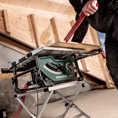 Mesa de serra Metabo com peça de madeira numa divisão com teto inclinado de madeira
